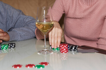 Woman hand making a move with dice in poker game. Cards, dices and glasess of champagne. Candid moment. Poker background lifestyle photography. Enjoying the moment, digital detox with friends.