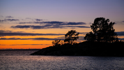 Fototapeta na wymiar Silhouette of trees on island during sunset