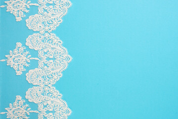 White laces on blue background isolated vertically. Copy space