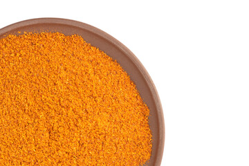 Red Chili pepper powder in clay plate isolated on white with copy space. Top view