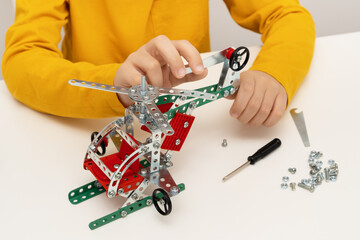 Boy playing with iron construction set for modelling.