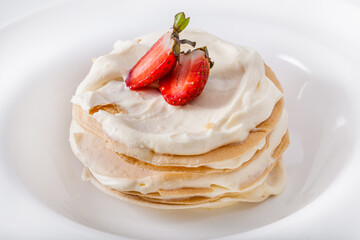 Pancakes with white cream and strawberries