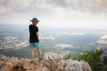 Man from behind standing on the edge of the mountain and watching a landscape. Hiking concept. People from behind. Portrait without face