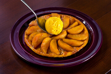 Dessert with pieces of marinated apples in jam and a scoop of ice cream