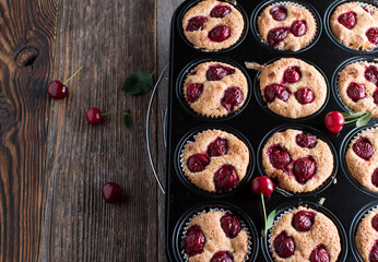 Muffins with sour cherries in a baking pan