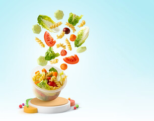Pasta salad falling into a plastic container isolated from the background with copy space