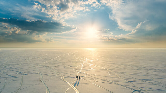 The two people walking through the endless snow field - Powered by Adobe