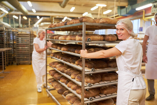 Bäcker Team schiebt Tablettwagen mit gebackenem Brot