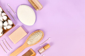 Eco friendly wooden beauty and hygiene products like comb and soap arranged on violet background