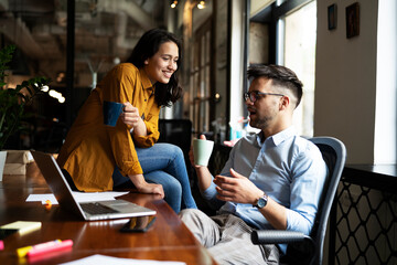 Colleagues in office. Businesswoman and businessman drinking coffee.