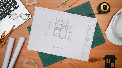 Flat lay blueprints, laptop, helmet, house model and tools on wooden table. Engineer, Architect...