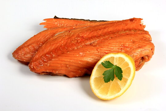 Hot smoked salmon trim and leftovers with bones and fins on white background.