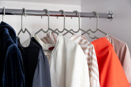 Clothes hanging on a clothes rack in a store or home closet.