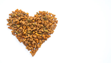 Dry food for cats or dogs in the shape of a heart on a white background. The concept of love and care for pets
