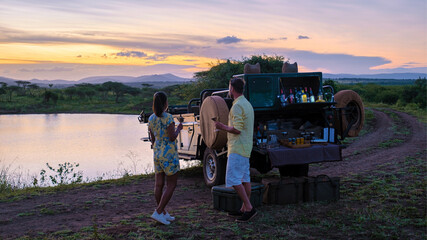 couple men and Asian woman on safari in South Africa, South Africa Kwazulu Natal, luxury safari car...
