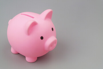 Pink piggy bank on grey background with copy space for text. Savings money concept.