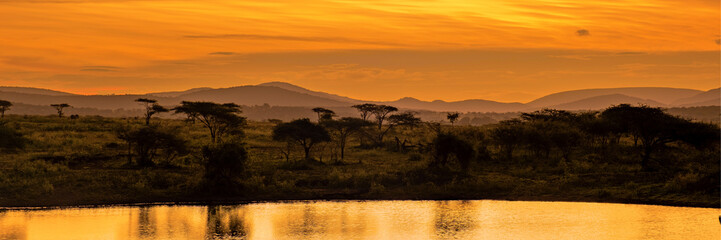 African sunset with lake trees and mountains, sunset by a water lake in Savannah South Africa....