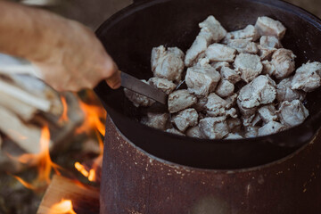 Recipe for traditional oriental pilaf in a cauldron in nature. Cooking. Recipes. Step-by-step photo...