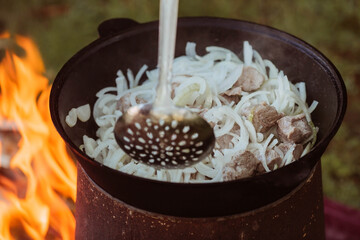 Recipe for traditional oriental pilaf in a cauldron in nature. Cooking. Recipes. Step-by-step photo...
