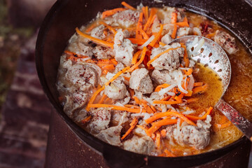 Recipe for traditional oriental pilaf in a cauldron in nature. Cooking. Recipes. Step-by-step photo...