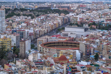 contemporary buildings in the city center against the overcast mountains