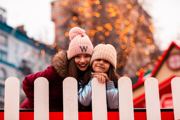 Two sisters, girlfriends, walk around the New Year's location in the city. They are cheerful and happy. Christmas, new year. vacation