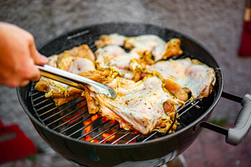 man chef cooking chicken meat on grill outdoor
