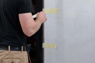 The use of painter's tape in the installation of the door, the tape restrains the deformation of...