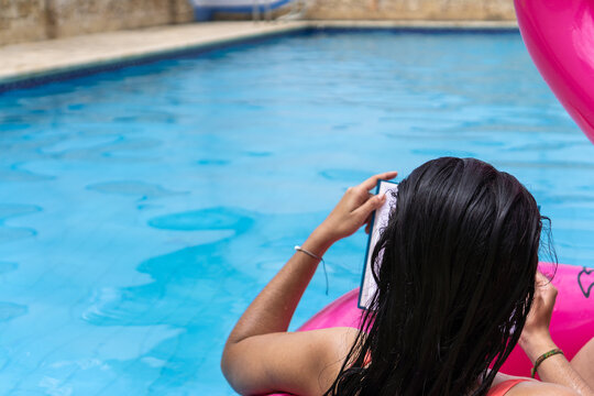 Woman Back Reading A Book In Pool