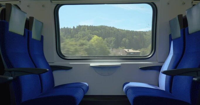 Moving train with empty seats or bench. Inside view, moving landscape out the windows, real time, no people. Swiss SBB public train in Europe