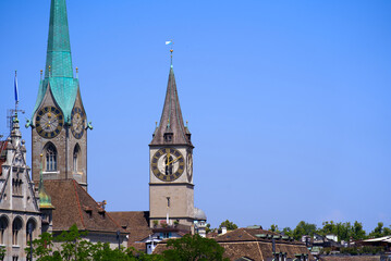 Fototapeta premium Medieval old town of Zürich with church towers of Women's Minster and St. Peter on a sunny hot summer day. Photo taken June 19th, 2022, Zurich, Switzerland.