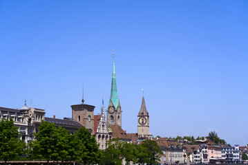 Fototapeta premium Medieval old town of Zürich with church towers of Women's Minster and St. Peter on a sunny hot summer day. Photo taken June 19th, 2022, Zurich, Switzerland.