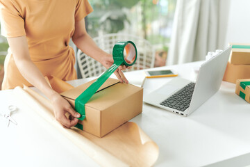 Woman using tape close the box to protect stuff before delivery to new home, Ordered online.