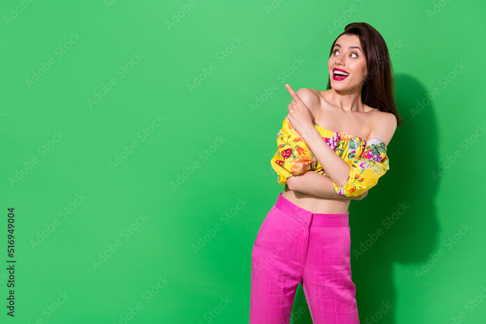 Wall mural portrait of excited cheerful girl look direct finger empty space offer proposition isolated on green
