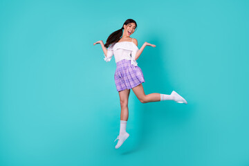 Full size photo of cheerful carefree lovely thai person jumping have fun isolated on cyan color background