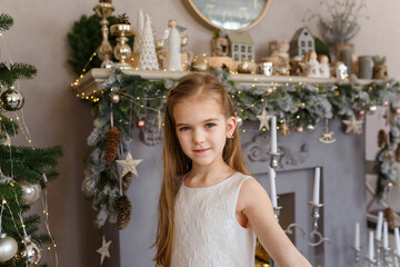 Beautiful little girl in white dress on decorated Merry Christmas background