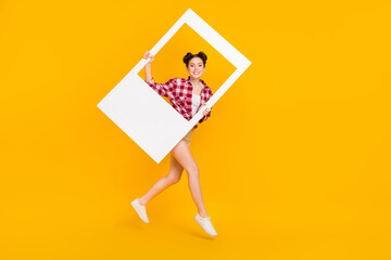 Full size photo of youth sweet lady jump step legs hold photo frame shopping shoot sale isolated bright color background
