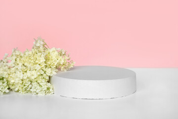 Round Podium with flowering hydrangea branches for product presentation. Abstract minimal...