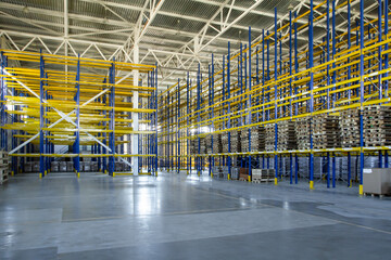 Interior of a modern warehouse storage of retail shop with pallet truck near shelves. Rows of steel...