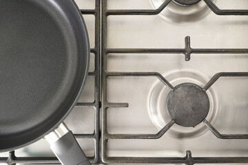 Empty frying pan on the stove, top view.