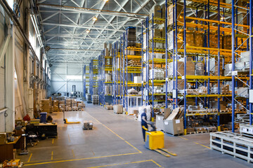 Interior of a modern warehouse storage of retail shop with pallet truck near shelves