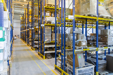 Interior of a modern warehouse storage with rows and goods boxes on high shelves