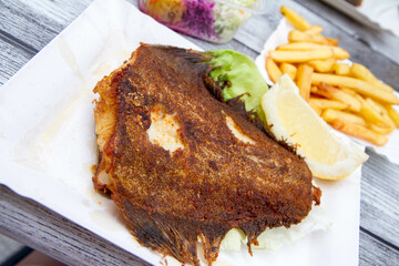 Fried halibut with French fries and salad served at a seaside restaurant
