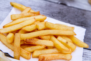 Portion of French fries on disposable paper tray