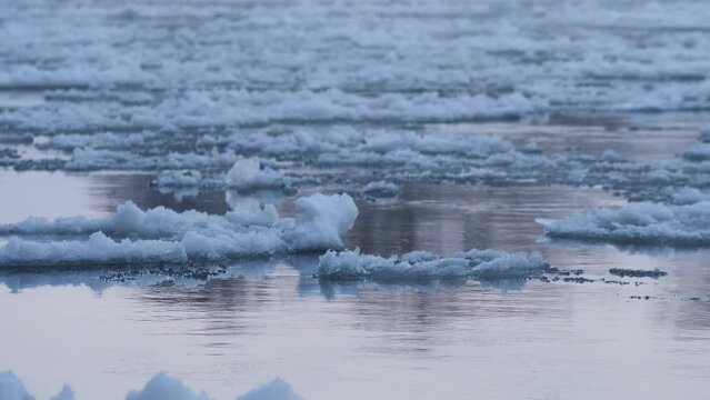 Ice floe in the river, low angle, shallow focus, slow motion.