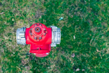Single red fire hydrant on green lawn.Autumn,spring,summer day.Copy space.Top view.
