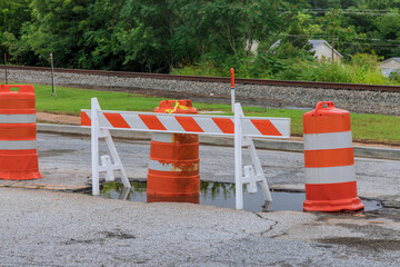 Damaged asphalt road repair its with signs for bypassing the repair site at the side of the road