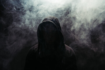Silhouette of hooligan on black background with smoke - obrazy, fototapety, plakaty