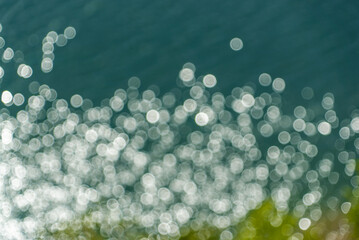 Glare on the water in out of focus . Abstract background.