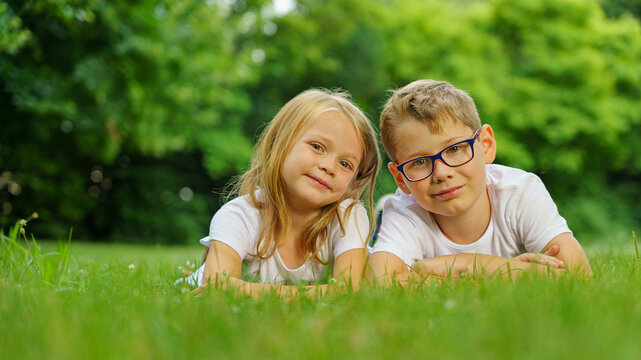 children lying on the green grass in the Park. The interaction of the children